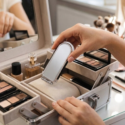 brosse à cheveux une main qui la dépose dans sa trousse à maquillage