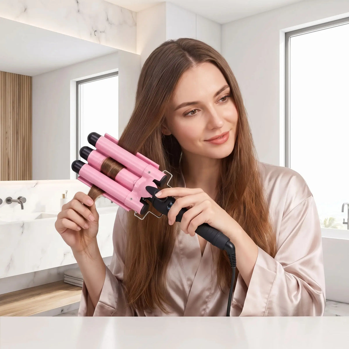 jeune femme aux longs cheveux châtains qui se coiffe avec le boucleur 3 tubes rose