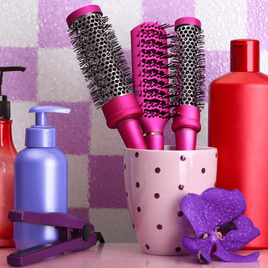 Brosses à cheveux posées dans un vase rose à pois