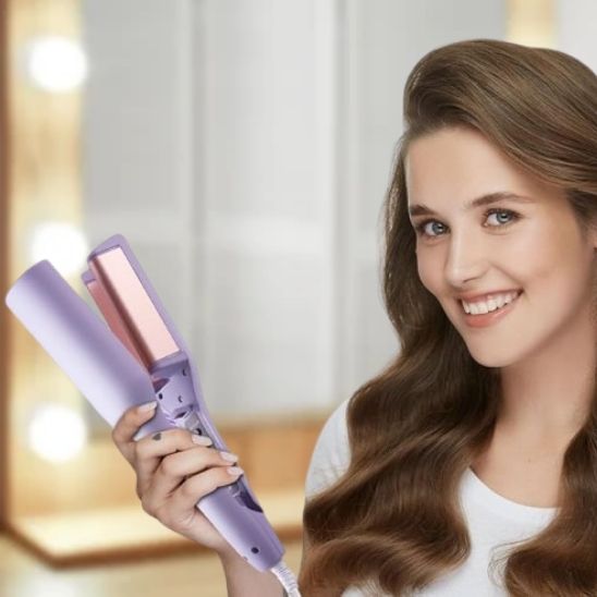 Jeune femme aux longs cheveux bruns qui sourit en tenant le bouleur couleur violet