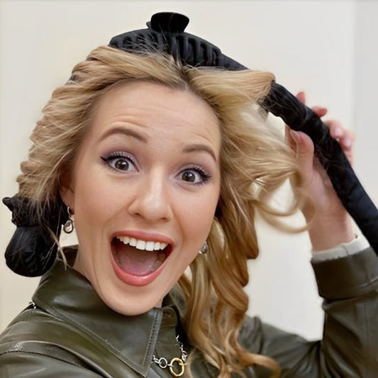 Jeune femme aux longs cheveux blonds souriante qui utilise le boucleur sans chaleur