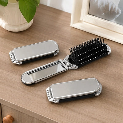 brosse à cheveux pliable posée sur un plan beige