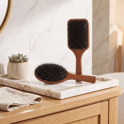 brosse poil de sanglier posée sur un plan blanc et beige sur une table en bois 