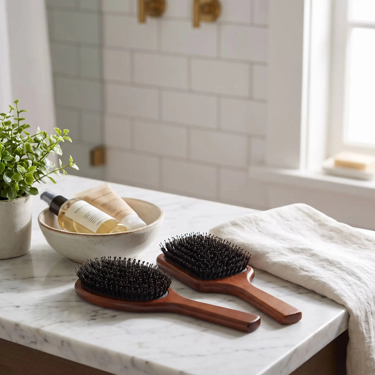Brosse poil de sanglier posée sur un  plan blanc et gris 