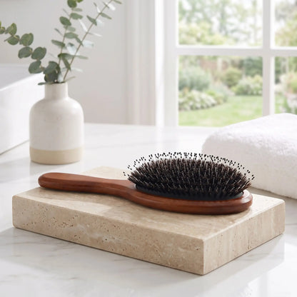 brosse poil de sanglier posée sur un plan crème de marbre