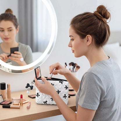 trousse de toilette blanche et noire une jeune femme se maquille devant le miroir