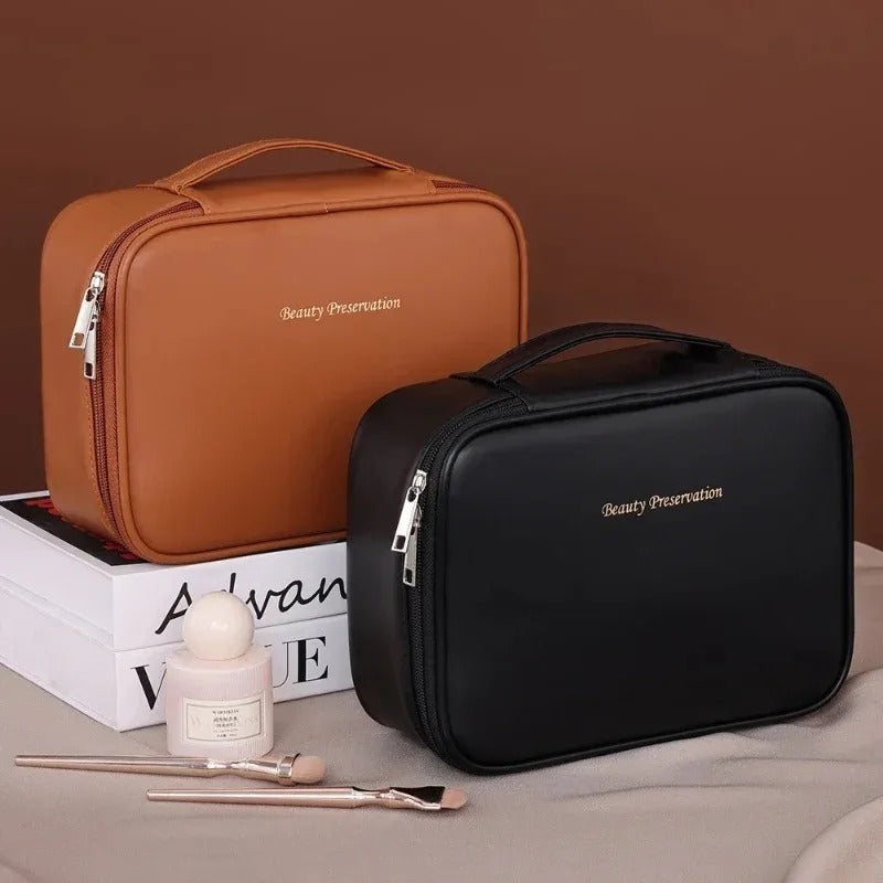 Trousse de toilette couleur noire et marron posées sur un plan couleur sable avec accessoires de beauté à côté