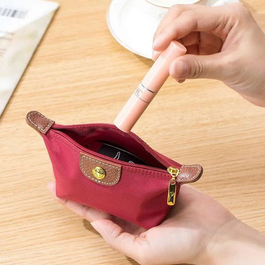 Une femme qui place des effets personnels dans sa trousse de toilette de couleur rouge