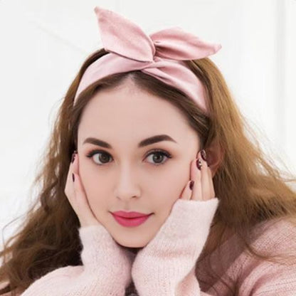 une jeune femme d'environ 20 ans portant le bandeau cheveux couleur rose