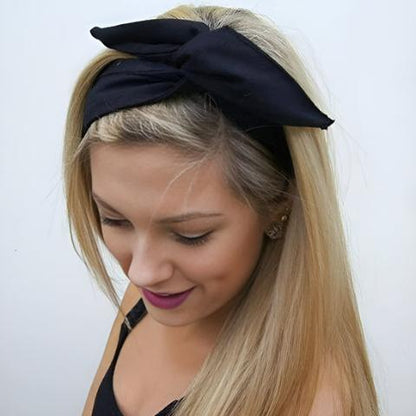 Une jeune femme d'environ 20-25 ans souriante qui porte le bandeau cheveux couleur noire