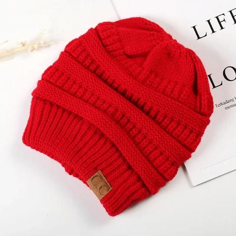 Bandeau cheveux couleur rouge posé sur un plan décoratif blanc