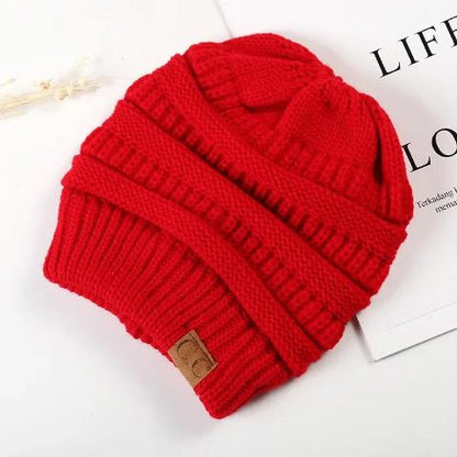 Bandeau cheveux couleur rouge posé sur un plan décoratif blanc