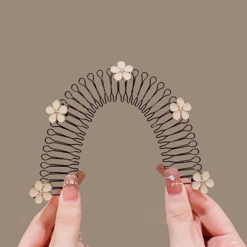 Bandeau cheveux fleurs blanches montré par une main afin d'en apprécier toutes les caractéristiques 