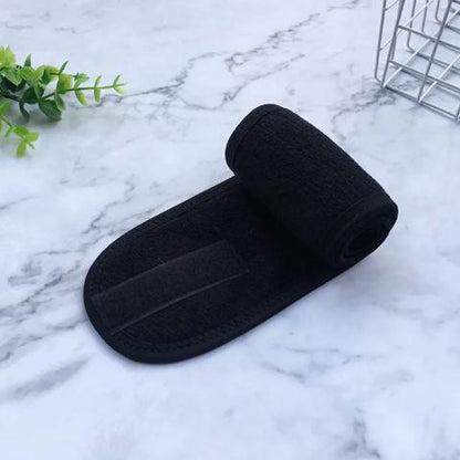 Bandeau cheveux noir posé sur un plan blanc et gris 