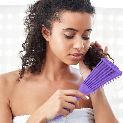 Jeune femme type se brossant les cheveux avec la brosse à cheveux bouclés pour cheveux épais de couleur violette