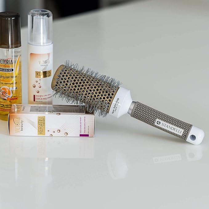 brosse à cheveux easybrush posée  sur un plan blanc et  adossée sur une boite d'un produit capillaire qui est montré debout juste à côté