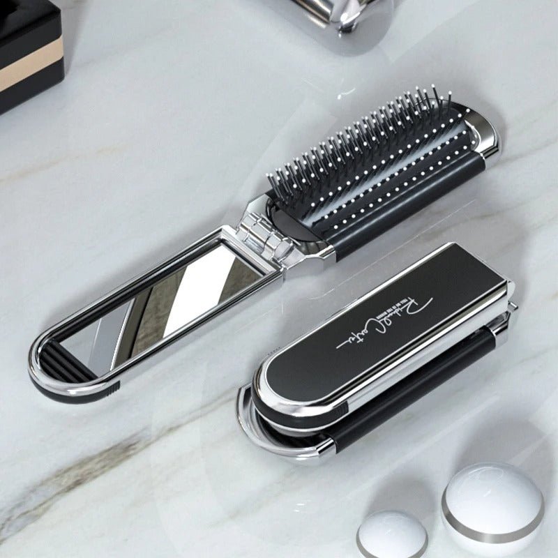 Brosse à cheveux démêlante de couleur argentée montrée pliée et dépliée posée sur un comptoir blanc