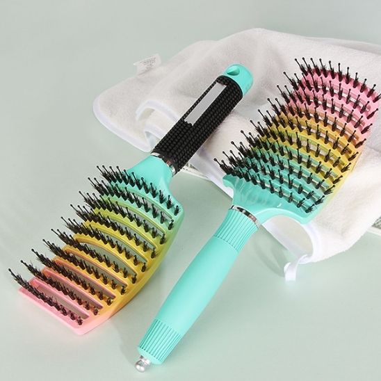 Brosse à cheveux poils mixtes posées sur un plan vert menthe