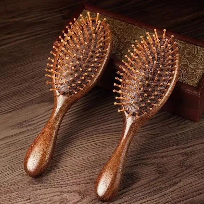 Brosse à cheveux en bois de santal de forme ronde appuyée sur un coffre en bois de couleur foncée