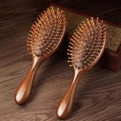 Brosse à cheveux en bois de santal de forme ronde appuyée sur un coffre en bois de couleur foncée