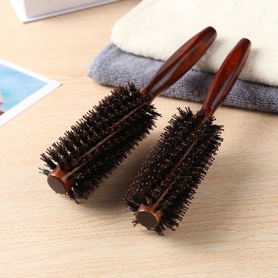 Brosse à poils de sanglier posées sur 2 draps de bain décoratifs de couleur crème et gris