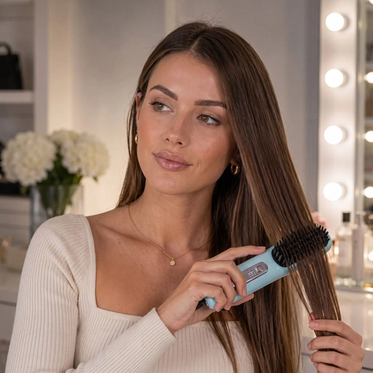 brosse chauffante jeune femme aux cheveux bruns qui se coiffe 