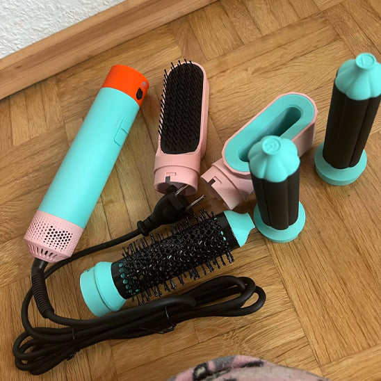 Brosse chauffante avec ses 5 accessoires posée sur un plan de bois