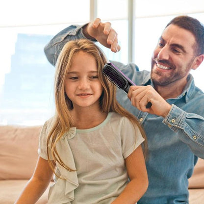un papa coiffe les cheveux châtains de sa fille avec la brosse chauffante de couleur noire 