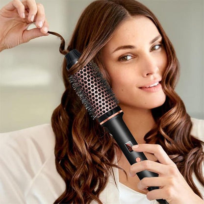 Jeune femme longs cheveux bruns qui se coiffe avec la brosse chauffante volumisante noire 