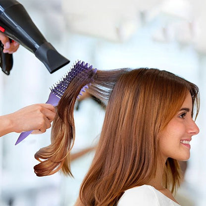 Jeune femme aux longs cheveux châtains qui se fait coiffer par un coiffeur avec la brosse cheveux bouclés  violette 