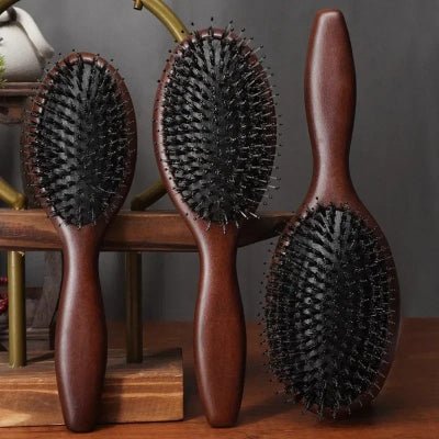 Brosse cheveux Poil de Sanglier - Bois foncé trois formats adossés contre une pièce de bois foncée décorative