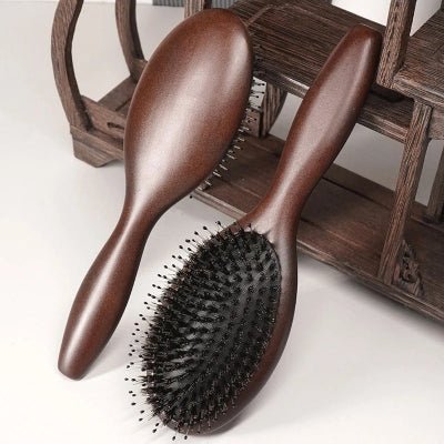 Brosse cheveux Poil de Sanglier - Bois foncé adossées contre une pièce de bois foncée 