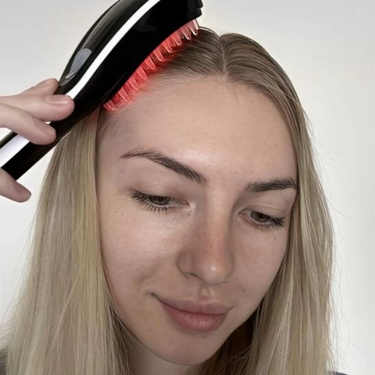 Brosse massante cheveux jeune femme qui brosse ses cheveux blonds 