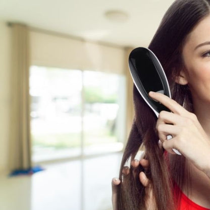 Brosse massante cheveux jeune femme qui se brosse les cheveux longs bruns 