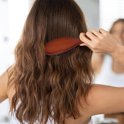 Brosse poil de sanglier jeune femme de dos qui coiffe ses longs cheveux châtains