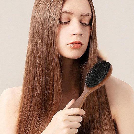 Brosse poil de sanglier jeune femme qui se brosse les cheveux 