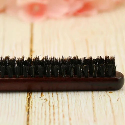 Brosse Poil de Sanglier en gros plan posé sur un plan de bois clair 