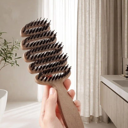 brosse poil de sanglier naturel une main qui tient la brosse afin d'en montrer les caractéristiques