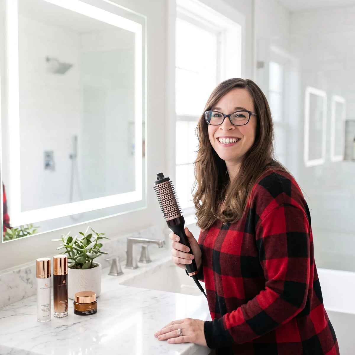 femme qui tient la brosse chauffante afin d'en apprécier les caractéristiques