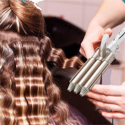 Jeune femme aux longs cheveux bruns bouclés se faisant coiffer par une professionnelle de la coiffure