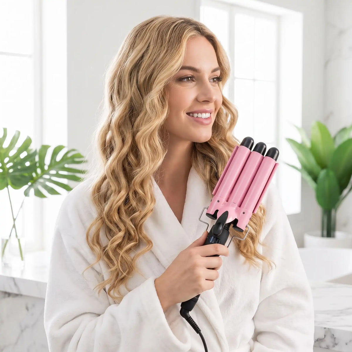 jeune femme aux  longs cheveux blonds qui se coiffe avec le boucleur 3 tubes 