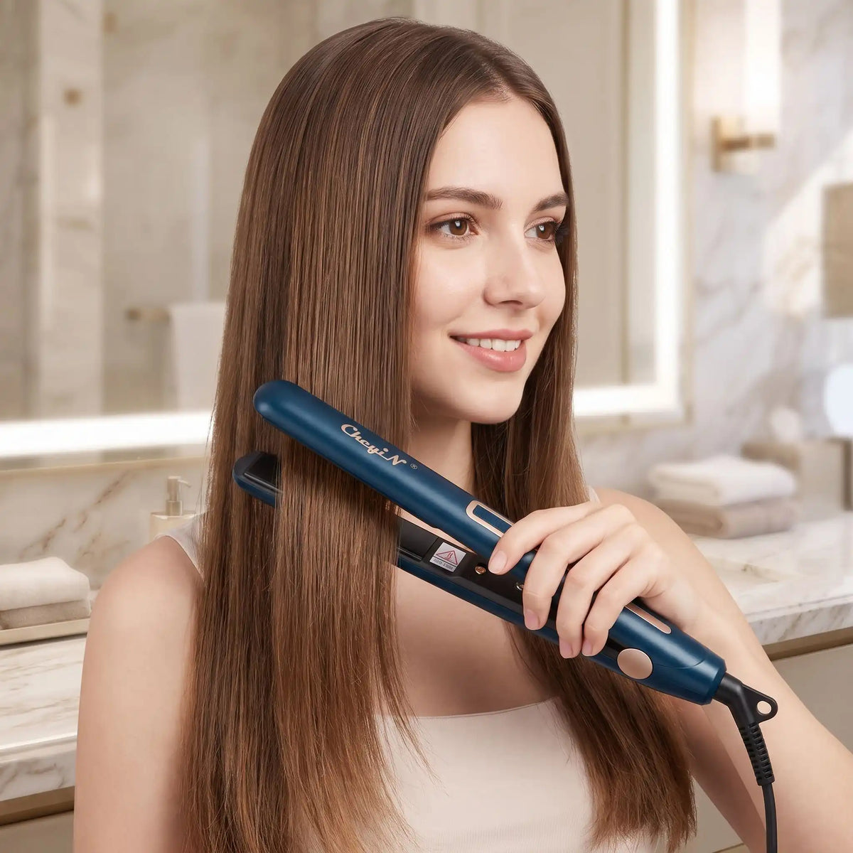 jeune femme qui coiffe ses cheveux avec le lisseur 