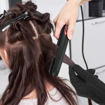 Jeune femme longs cheveux bruns qui se fait coiffer par une professionnelle de la coiffure avec le lisseur