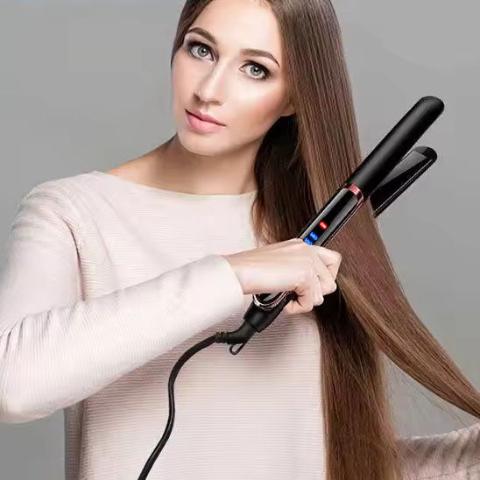Jeune femme cheveux longs bruns qui se coiffe avec le lisseur