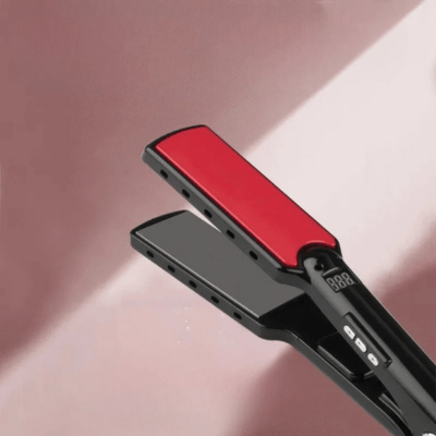 Lisseur couleur noir et rouge posé sur un plan rose 