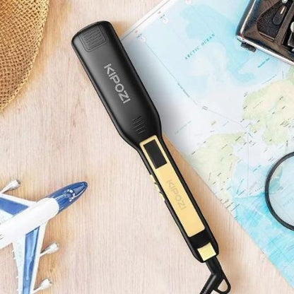 lisseur noir posé sur un plan en bois avec accessoires décoratifs de voyage à côté