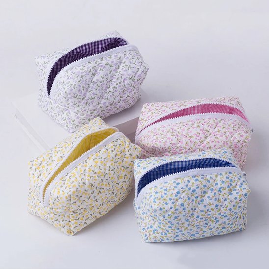 Trousse de toilette 4 coloris offerts posée sur un plan blanc 