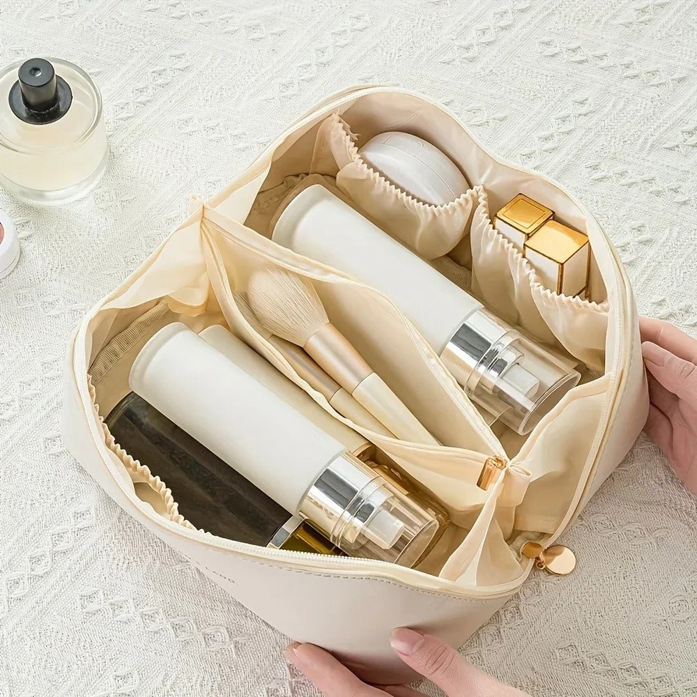 deux mains de femme qui tient la trousse de toilette ouverte afin d'en apprécier la capacité 