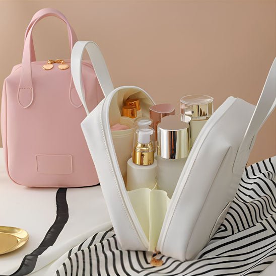trousse de toilette sac à main couleur crème et rose posées sur un plan décoratif blanc et noir 