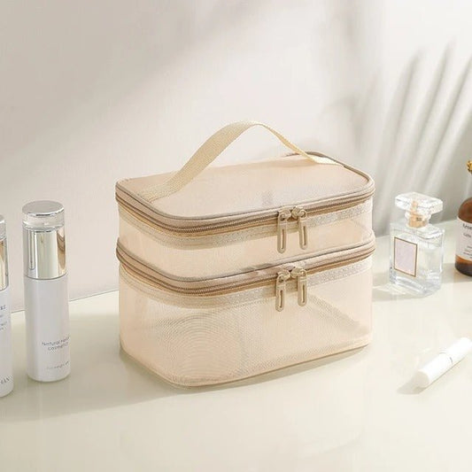 Trousse de toilette couleur crème posée sur un plan crème avec accessoires de maquillage à côté 